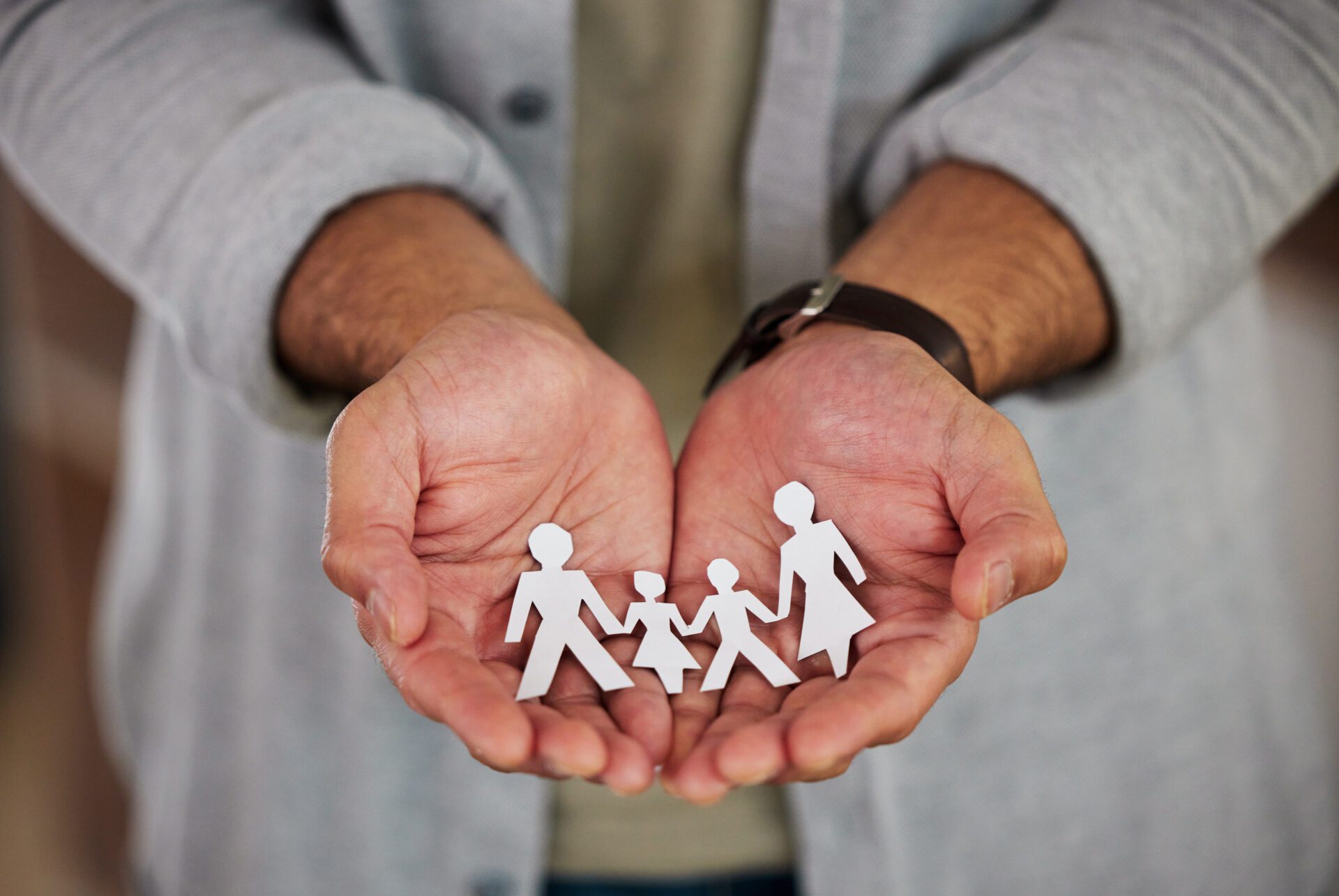 The future is in your hands. a businessman holding a cutout of people.